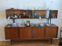 Front view of full cabinet showing upper sliding glass display and lower storage base