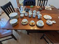 Full set of Eschenbach Bavarian china arranged on wooden table, showing major pieces including teapot, serving plates, cups, and saucers.