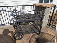 Full view front right showing two-tier scrollwork cart with large wheels and casters