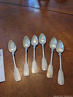 Six Yoehr 800 silver spoons arranged on wooden table, showing overall condition and size.