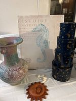 Overall lot showing the vase, seahorse canvas print, star and moon nesting boxes, and terracotta sun wall decoration