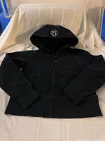 Black Lululemon Scuba hoodie laid flat, front view showing full zipper and fitted shape