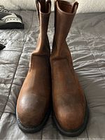 Front view of the pair of brown leather slip-on boots showing smooth leather upper and slip-on tabs.