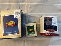 Photo showing three Hallmark Keepsake collectible ornaments in their original boxes with price tags on top.