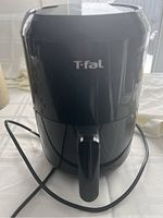 Front view of black T-fal air fryer with logo, power cord visible.