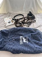 All leather leashes, choker leash, Canada Pooch athletic dog hoodie, Pawscout tag, and gloves laid out on fabric background