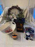 Overall lot showing all items including wreath, lantern, candy bowl, ribbon, and makeup items