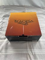 Closed Teaopia branded box showing logo and slogan.