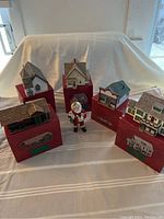 Overview photo of all five village buildings and Santa figurine arranged on boxes