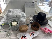 Photo showing assembled set items including bamboo king sheets, Starbucks mug, Disney socks, fedora hat, baskets, candle pot, margarita glass and hair styling tool