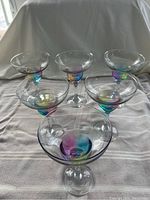 Set of six margarita glasses on a neutral surface with soft lighting showing full set viewed from above and slight angle.