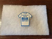 Front of the pin showing white T-shirt shape with blue text 'FRANKIE SAYS RELAX DON'T DO IT'.