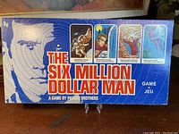 Photo of the game box cover showing six million dollar man illustration and game branding.