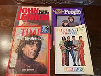 Four magazines and a book related to John Lennon and The Beatles, showing covers.