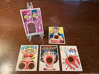 Front sides of 5 vintage Laugh-In punch-out cards, including Goldie, Joanne, Ouch!, Uncle Sam, and Jess & Mom character cards with visible punched-out holes.