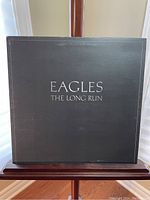 Front cover of the vinyl record sleeve for Eagles The Long Run showing black design with white text.