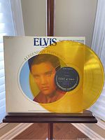 Front cover of 'Elvis Vol. 3 A Legendary Performer' showcasing yellow translucent vinyl and original printed sleeve with Elvis portrait.