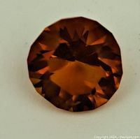 Front view of the faceted round citrine gemstone showing deep amber-brown color and internal facets.