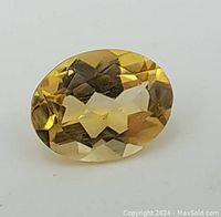 Close-up photo showing the top view of the oval cut citrine gemstone revealing its golden yellow faceted surface and internal clarity.