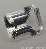 Close-up of a colorless emerald cut gemstone highlighting its clarity and cut facets.