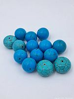 Multiple blue round stone beads displayed together showing variation in blue hues and veining patterns.