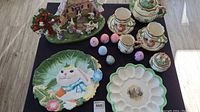 Full overview of the Easter themed ceramic serveware and village figurine on table.