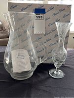 Two Princess House glass pieces displayed in front of original box, showing clean and like new condition, one pitcher and one vase.