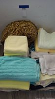 Assorted bath towels and washcloths arranged together showing various colors and patterns including leopard print and blue floral designs.