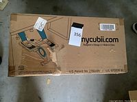 Photo of the Cubii Cubicle Bike in its original packaging box showing external graphics and branding.