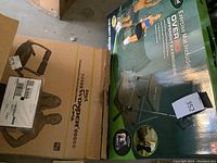 Photo showing Wonder Core exercise machine in brown cardboard box and green exercise mat box with exercise illustrations.