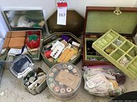Photo showing containers of threads, buttons, jewelry box with necklaces, sewing pins and other supplies