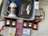 Overall view of lot contents including stein, telephone box, display cases with coins