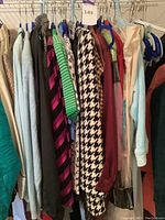 Wide view of hanging garments showing various colors and patterns including houndstooth, striped, solid colors in pastel and bright tones.