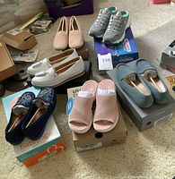 Overview of all six pairs of unworn women's shoes size 7 on boxes.