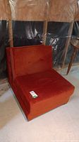 Orange flip chair with velvet-like upholstery folded in chair form
