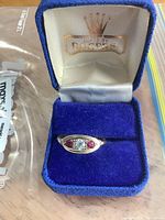 Ring in blue box, showing front view with stones and interior lid marking