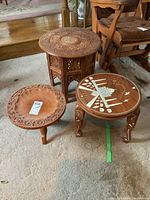 Three wooden tables grouped closely showing various sizes and designs.