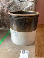 Full exterior view of a number 2 stoneware crock with brown glazed top and white bottom with a blue heart and number 2 on the front.