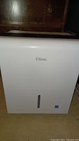Front view of white Classic dehumidifier showing Classic logo and water level window.