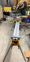 Full view of DeWalt miter saw mounted on DW723 stand with workpiece supports extended