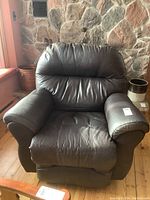 Front view of the bonded leather rocker recliner showing cushioned back, seat, and armrests.
