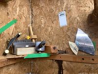 Photo showing multiple woodworking tools including burnishing block, chopping blade, Veritas card scraper, and marking gauge on wooden shelf