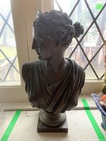 Front view of metal bust on window ledge