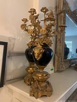 Two candelabras displayed side by side on mantel with mirror in background