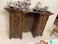 Front view of cabinet with silver tea set on top
