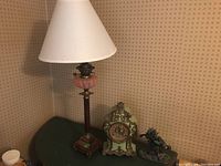 Full view of lamp, clock and figurine grouped on table