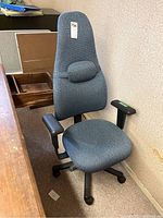 Front view of the upholstered office chair showing high back with lumbar support and armrests.