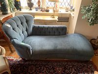 Side view showing full settee length with tufted upholstery and wooden feet