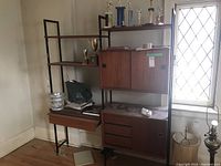 Full view of metal frame shelving unit with trophies on top shelf