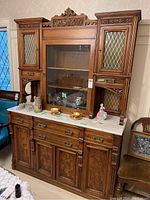 Front view of entire sideboard showing marble top, central display cabinet and flanking storage sections